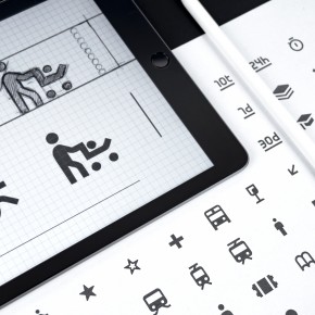 Icons auf einem Tablet und einem Blatt Papier